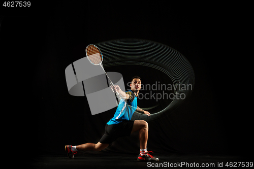 Image of Young male badminton player over balck background