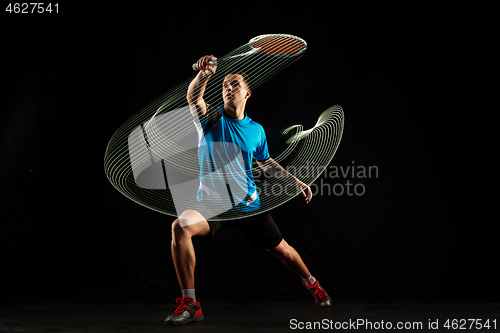 Image of Young male badminton player over balck background