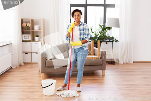 Image of african woman or housewife cleaning floor at home