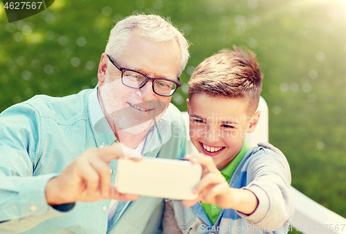 Image of old man and boy taking selfie by smartphone