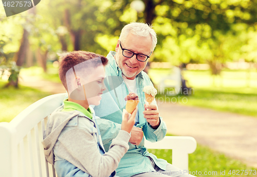 Image of old man and boy eating ice cream at summer park