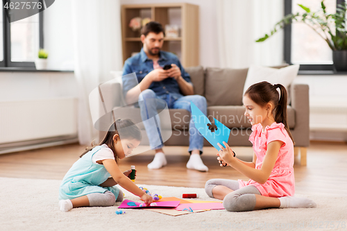 Image of happy sisters doing arts and crafts at home