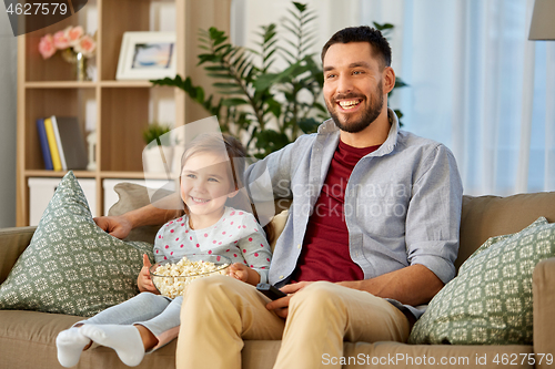 Image of happy father and daughter watching tv at home