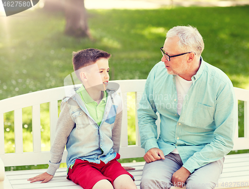 Image of grandfather and grandson talking at summer park