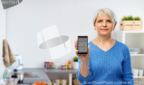 Image of senior woman showing smartphone at kitchen