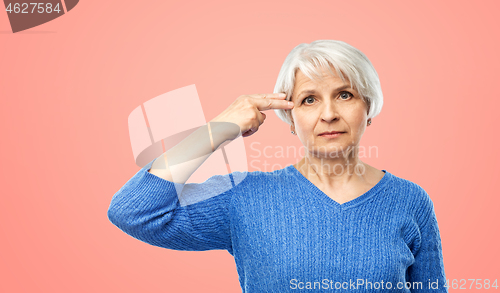 Image of senior woman making finger gun gesture