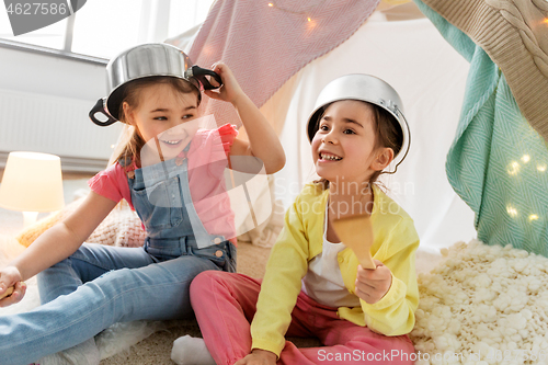 Image of girls with pots playing in kids tent at home