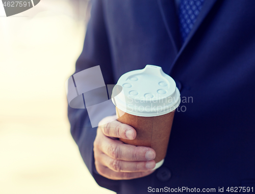 Image of senior businessman with coffee cup outdoors