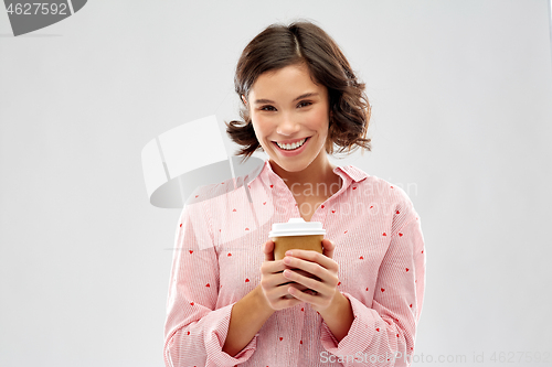 Image of happy young woman in pajama with cup of coffee