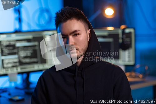 Image of asian hacker in dark room with computers at night