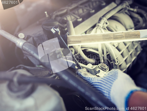 Image of mechanic man with wrench repairing car at workshop