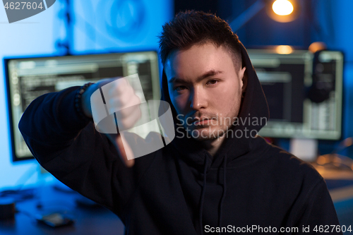 Image of asian hacker in dark room with computers at night