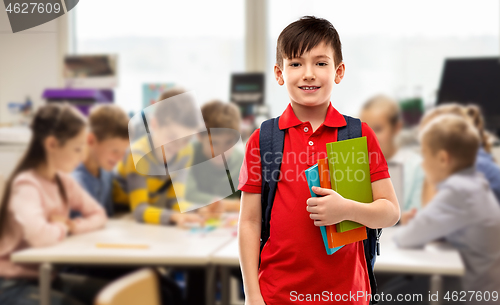 Image of smiling student boy with books and school bag