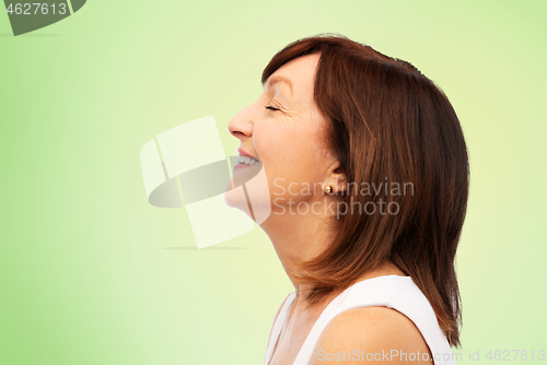 Image of profile of smiling senior woman over white