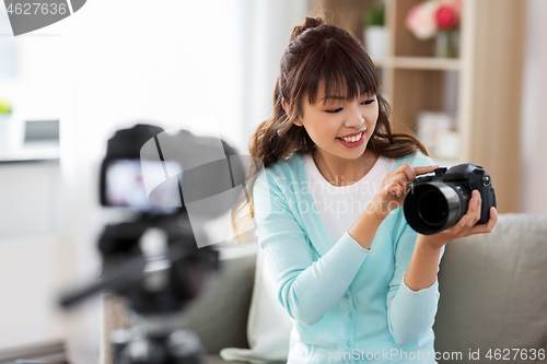 Image of asian female blogger with camera recording video