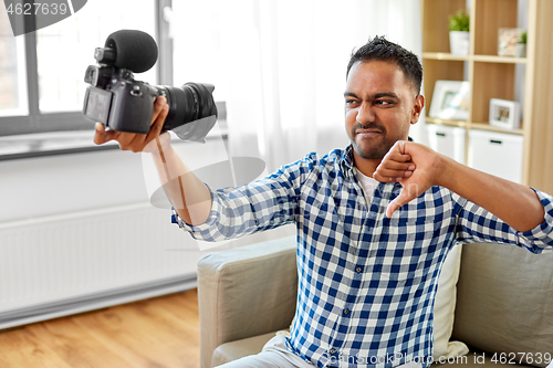 Image of male video blogger with camera blogging at home