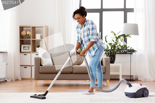 Image of woman or housewife with vacuum cleaner at home