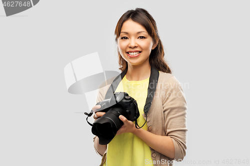 Image of asian female photographer with digital camera