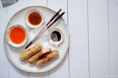 Image of Fried Chinese Thai or Vietnamese traditional spring rolls or nems served on ceramic plate