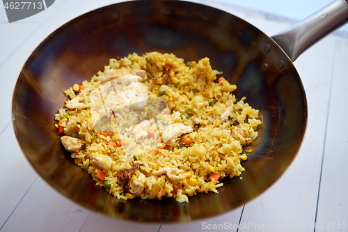 Image of Delicious Thai dish in hot Wok. Fried chicken with rice and vegetables.