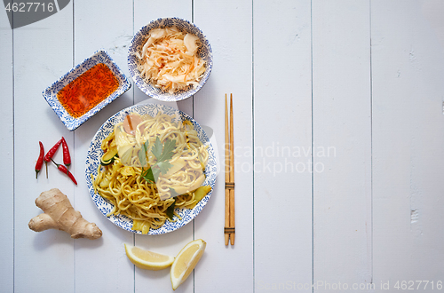 Image of Tasty and Fresh Noodles with Chicken and vegetables served on ceramic plate with chopsticks