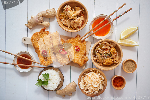 Image of Deep fried Crispy chicken in breadcrumbs served on white wooden table with salad, spices