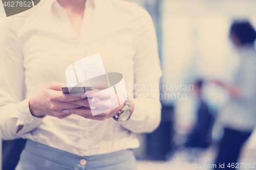 Image of Elegant Woman Using Mobile Phone in startup office building