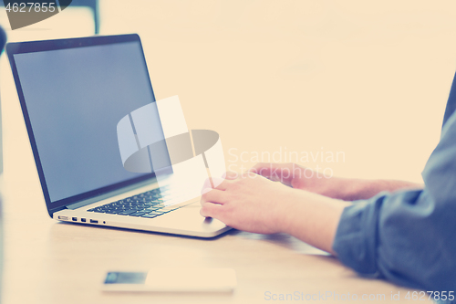 Image of businessman working using a laptop in startup office