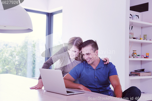 Image of couple using laptop at home