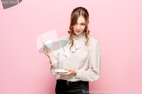 Image of The serious frustrated young beautiful business woman on pink background