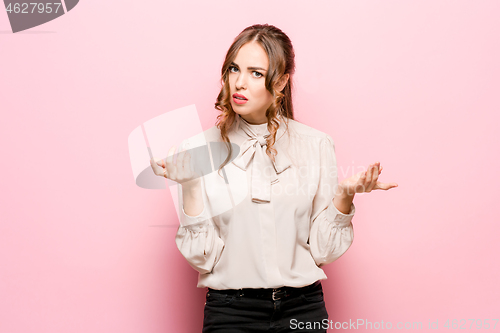 Image of Beautiful female half-length portrait isolated on pink studio backgroud. The young emotional surprised woman