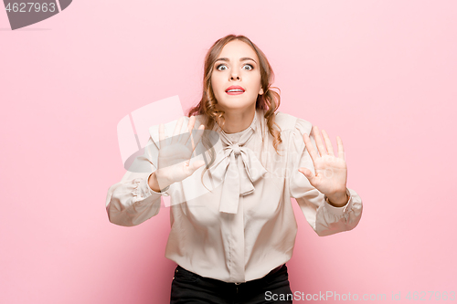 Image of Beautiful female half-length portrait isolated on pink studio backgroud. The young emotional surprised woman