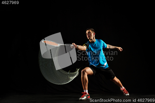 Image of Young male badminton player over balck background