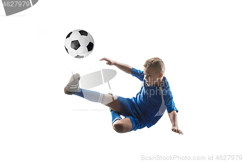 Image of Young boy with soccer ball doing flying kick