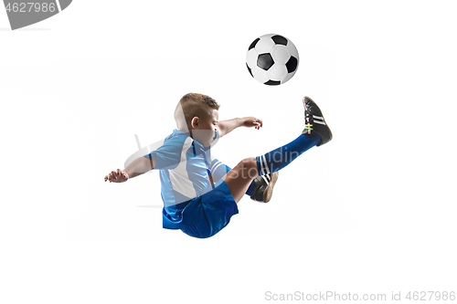 Image of Young boy with soccer ball doing flying kick