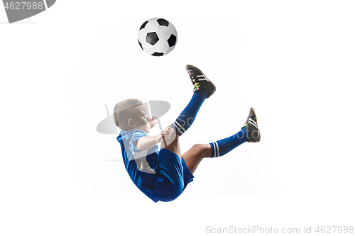 Image of Young boy with soccer ball doing flying kick