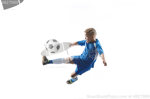 Image of Young boy with soccer ball doing flying kick