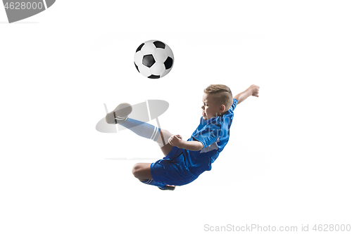 Image of Young boy with soccer ball doing flying kick