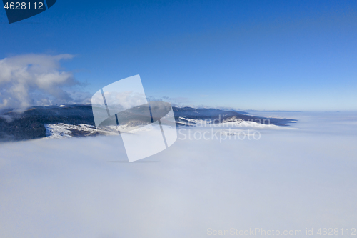 Image of Flying drone above misty valley