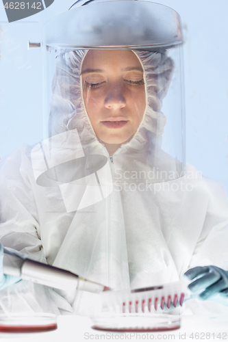 Image of Female scientist working in the corona virus vaccine development laboratory research with a highest degree of protection gear.