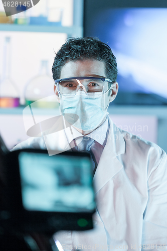 Image of Laboratory hospital clinic doctor, scientist or exper, wearing protacive mask while addressing public in media interview explaining preventive measures against corona virus pandemic outbreak