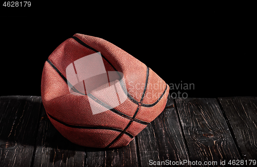 Image of Deflated and rumpled old ball on a wooden floor