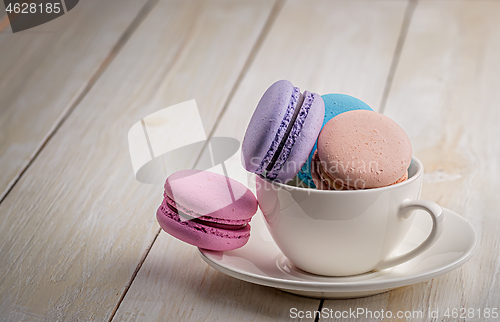 Image of Macaroons in cup on wooden table