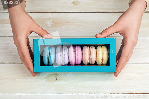 Image of Girl\'s hands holding box of macaroons