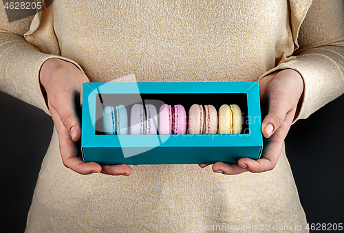 Image of Girl hold one gift box with macaroons