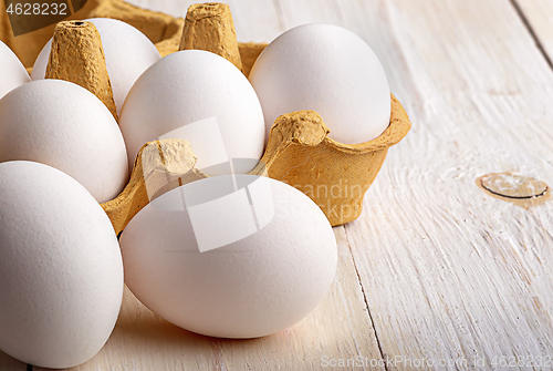 Image of Eggs near the tray on white table closeup