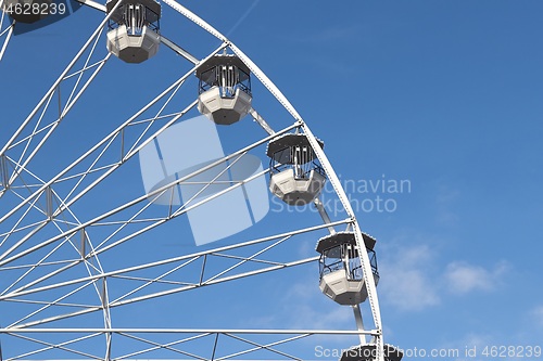 Image of White ferris wheel against blus sunny sky