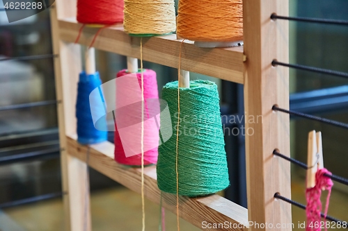 Image of Rack of colorful yarn rolls for knitting