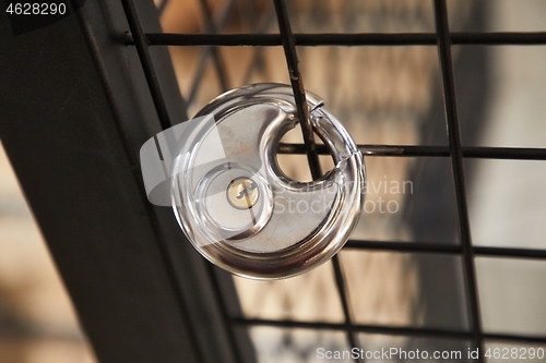 Image of Padlock fixed on a metal fence