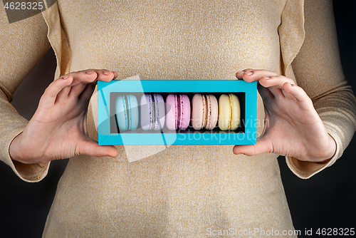 Image of Girl hold colorful macaroons in gift box